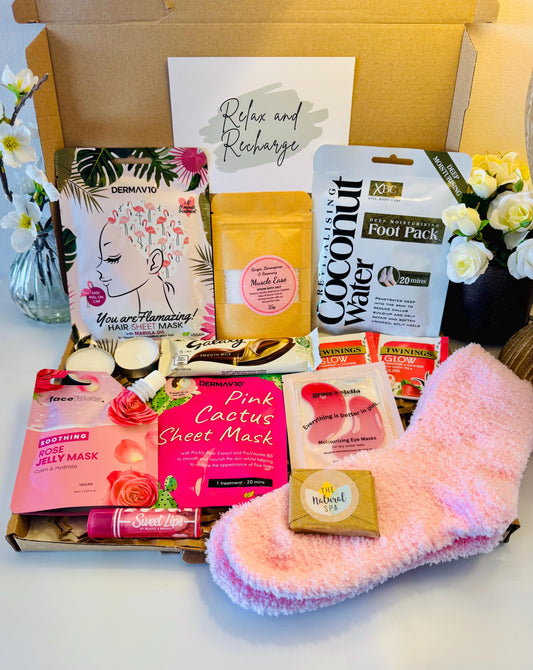Pamper gift box includes pink cosy socks, scented lip balm, travel soap, rose jelly face mask, face sheet mask, hair sheet mask, bath salts, coconut foot pack, pink under eye masks, galaxy chocolate bar hot drink options. Comes with the option to add your own personalised message ready to send direct to the recipient