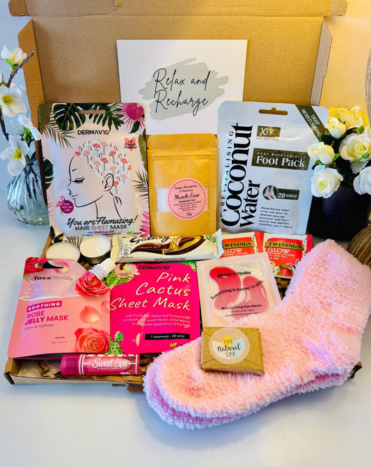 Pamper gift box includes pink cosy socks, scented lip balm, travel soap, rose jelly face mask, face sheet mask, hair sheet mask, bath salts, coconut foot pack, pink under eye masks, galaxy chocolate bar hot drink options. Comes with the option to add your own personalised message ready to send direct to the recipient