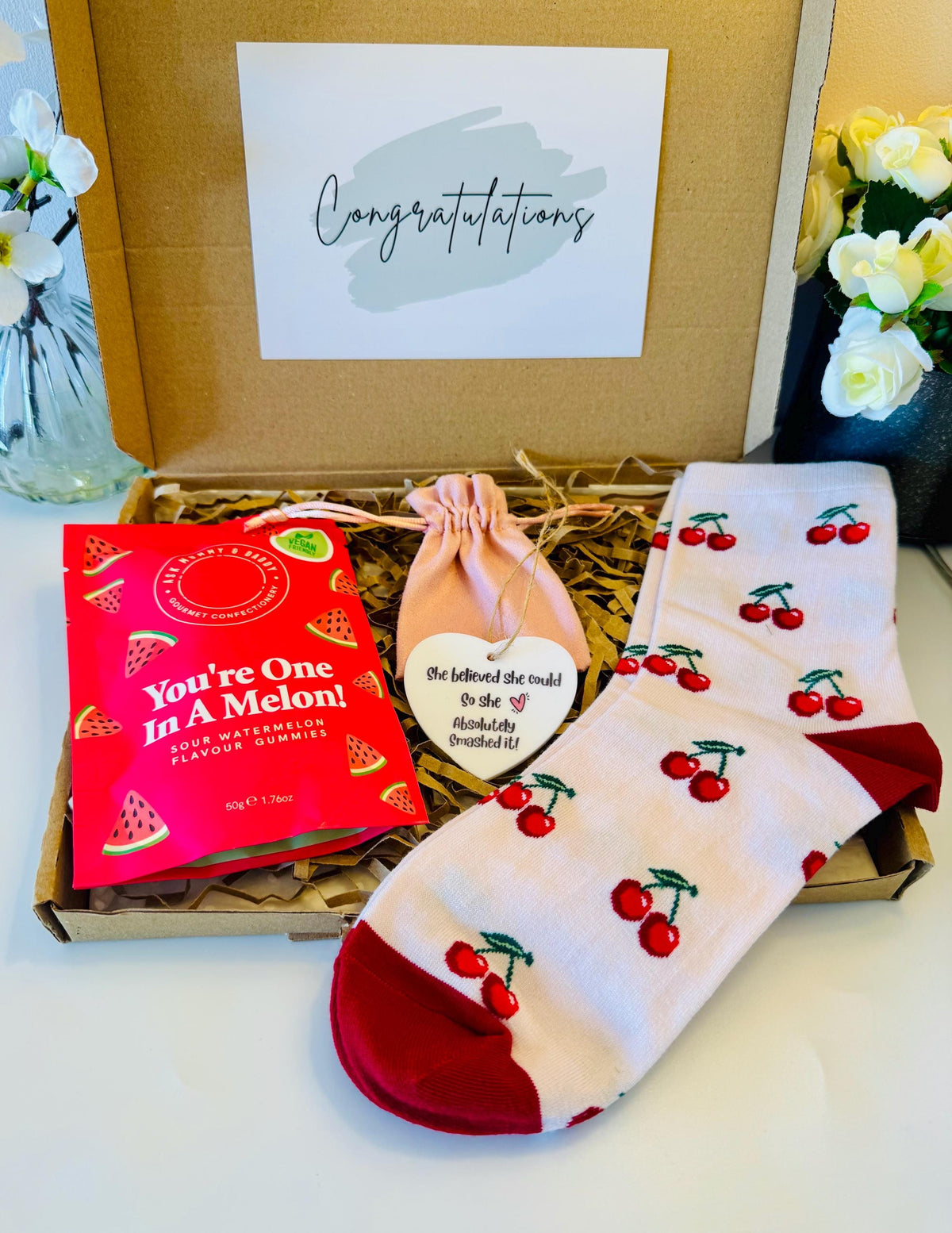 our congratulations box includes a pair of cherry socks, ‘you’re one in a melon’ watermelon sweets, and a ‘she believes she called so she absolutely smashed it’ heart keepsake. With an option of gift cards and your own personalised message delivered straight to the recipient