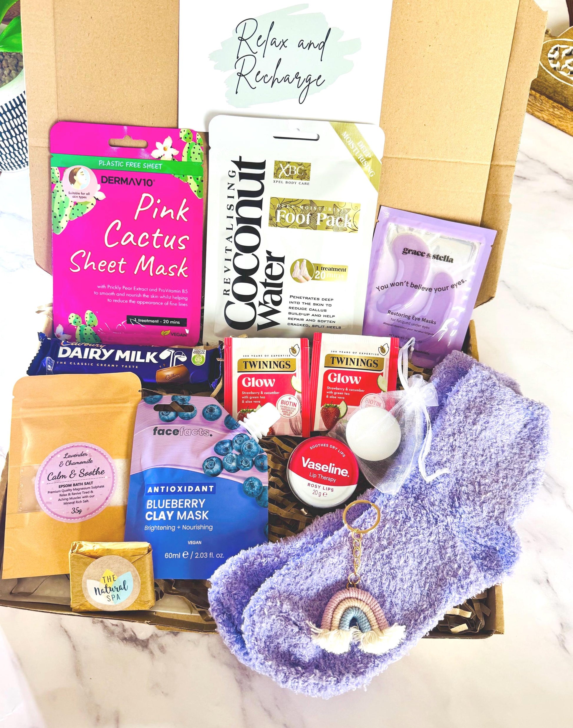 our hug pamper hamper gift includes cosy socks, rainbow keyring, bath salts, mini travel soap, face sheet mask, foot pack, Cadbury chocolate bar, clay face mask, under eye mask, Vaseline tin, tea light candle and a drink option. Comes with your now personalised message ready to send direct to the recipient