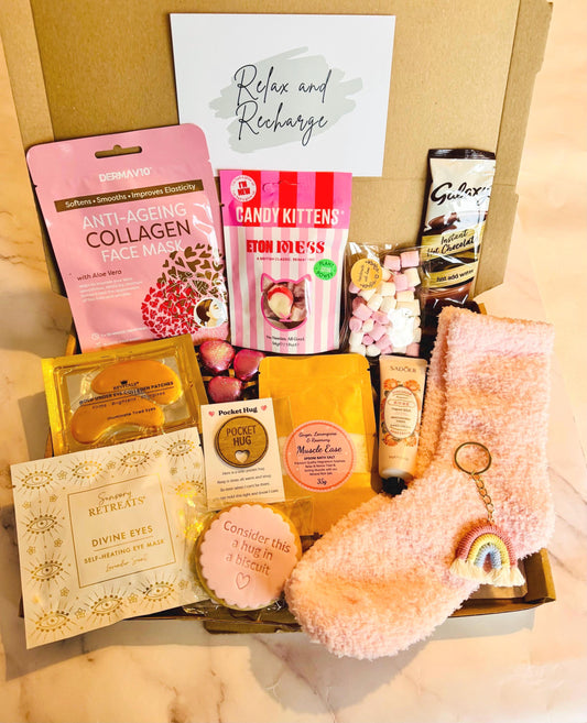 our hug in a box A4 Letterbox Option includes pink cosy socks, rainbow keyring, face sheet mask, heated eye mask, gold collagen eye mask, bath salts, hand cream, iced hug biscuit, candy kitten Eton mess sweets, small bag of mini marshmallows, hot chocolate sachet and a pocket hug token. sealed and ready to send to your loved one