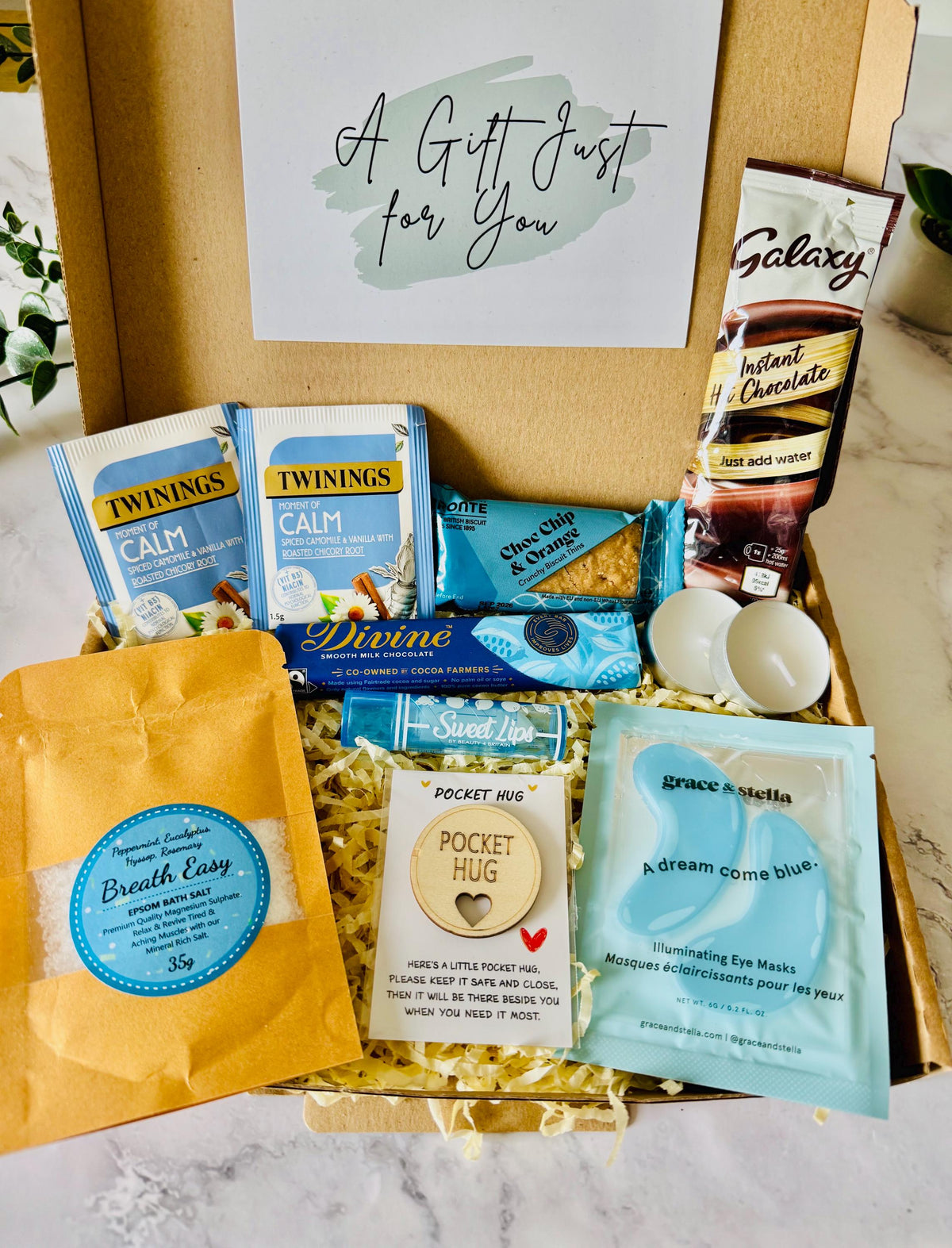 our hug in a box relaxation gift comes with bath salts, a hug token keepsake, under eye mask, tea light candles, pack of biscuits, divine chocolate bar, herbal tea, hot chocolate and a lip balm….comes with your own personalised message ready to send direct to the recipient