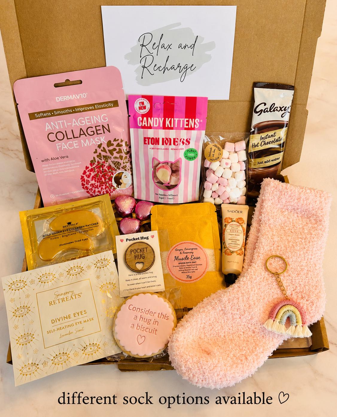 our hug in a box - includes pick cosy socks, hug biscuit, candy kitten sweets, hug token, rainbow keyring, self heating eye mask, gold collagen under eye masks, face sheet mask, hot chocolate sachet, mini marshmallows, bath salts, Handcream….ready to shit direct to the recipient