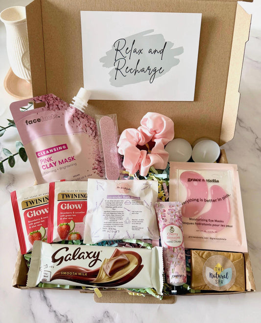 May include: A self-care gift box containing a variety of items. Includes a pink clay mask, pink hair scrunchie, nail file, tea bags, a Galaxy chocolate bar, under eye masks, hand cream, 2 tea light candles and a travel soap. With a choose of a gift card with your own personalised message ready to send direct to the recipient