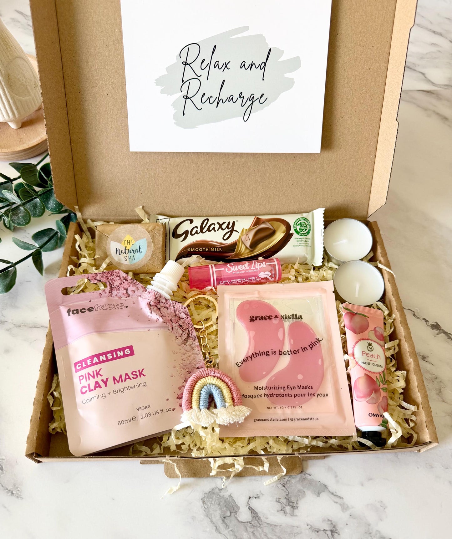 our pamper gift box for her comes complete with moisturising under eye masks, hand cream, pink rainbow keyring, face clay mask, travel soap, lip balm, Galaxy chocolate bar & 2 tea light candles. with your chosen gift card complete with your own personalised gift message ready to send direct to the recipient or send to yourself