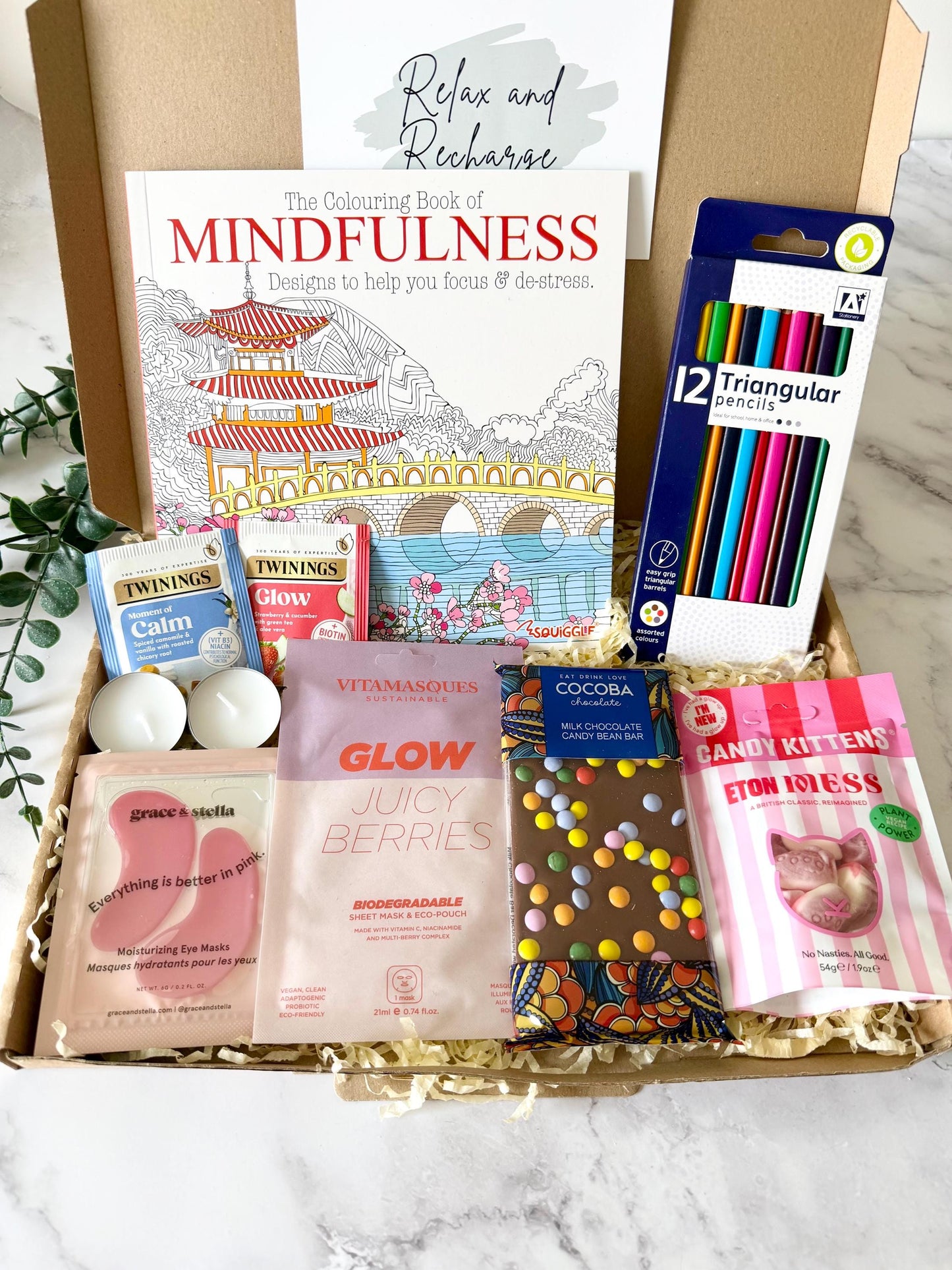 our distraction recovery get well soon gift includes a colouring book a set of 12 colouring pencils, a face sheet mask, a milk chocolate bar, under eye masks, herbal two (or select a different drink when ordering) candy kittens Eaton mess flavour and 2 tea light candles. with your chosen gift card and a personalised message ready to send direct to the recipient